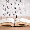 Opened book with flying letters